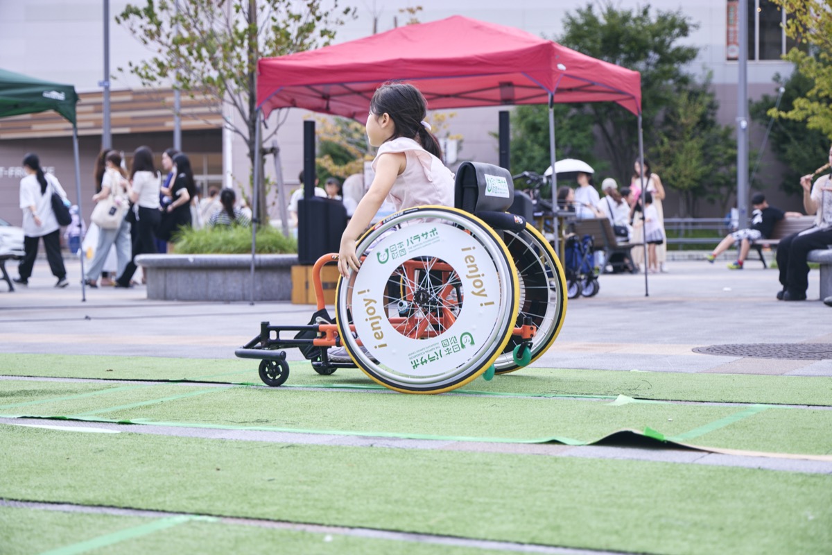 競技用車いすを体験する子ども